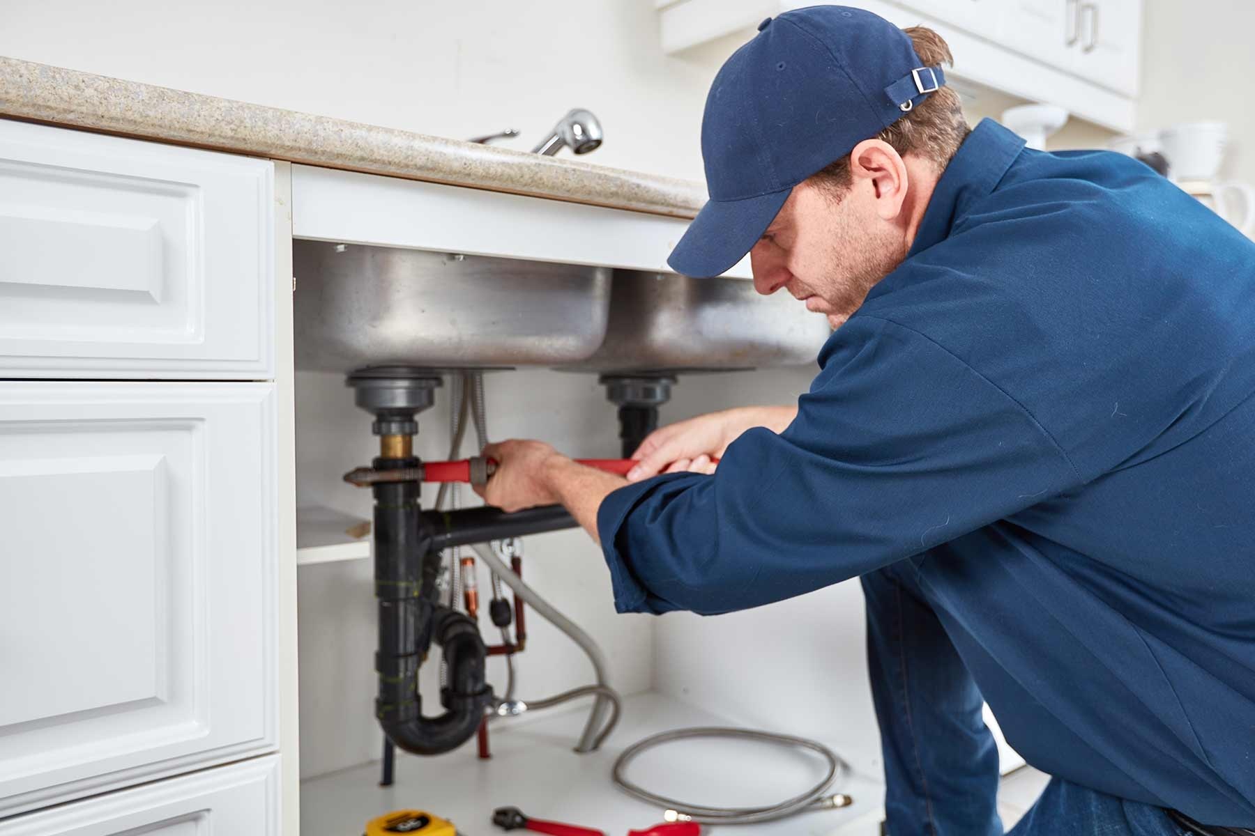 Garbage Disposal Repair - Professional plumber repairing kitchen sink pipes in a residential setting