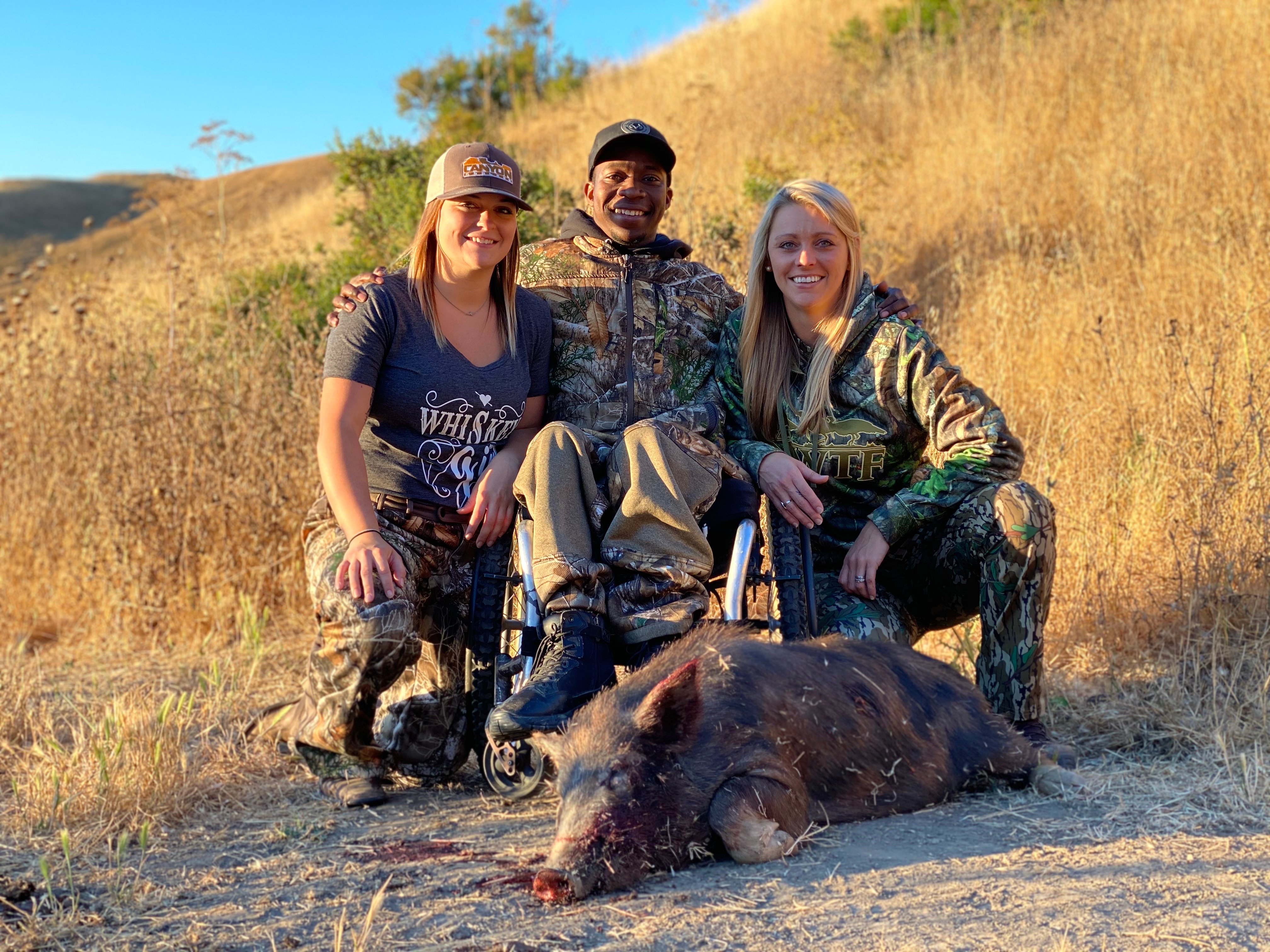 Joshua with two friends and a wild hog on a California hillside
