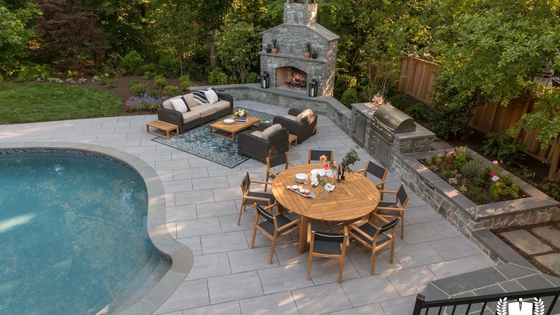 Elegant stone patio with outdoor kitchen and pool view