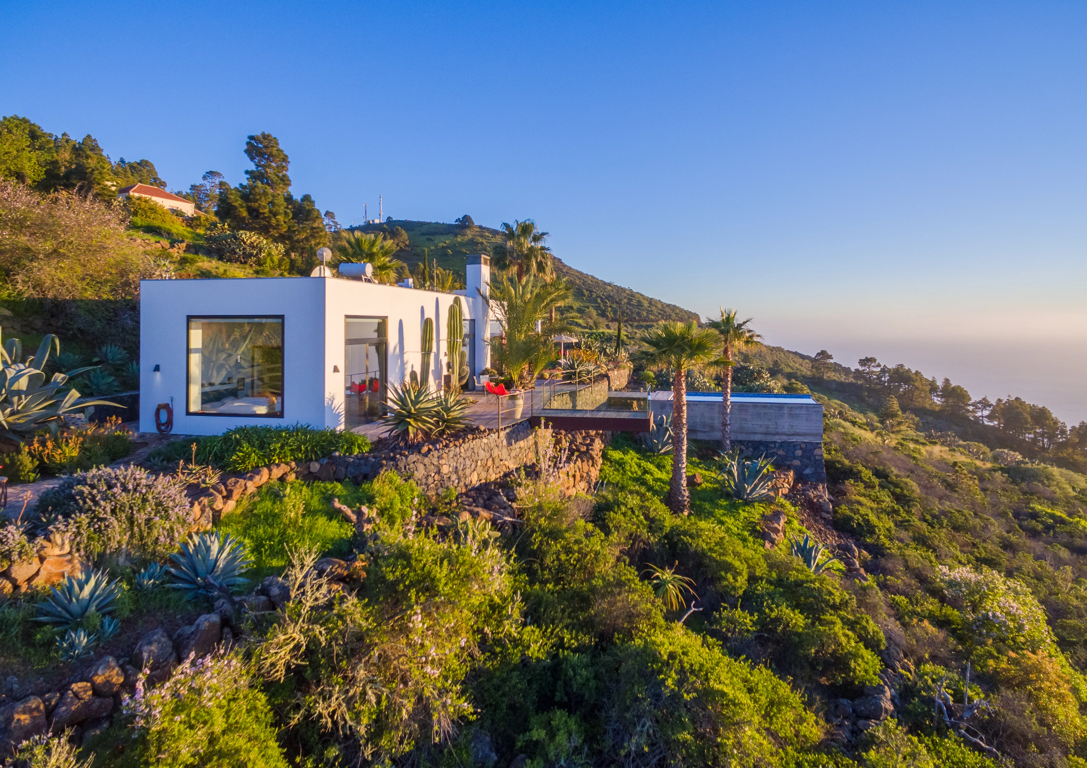 Aerial hillside villa with ocean panorama at golden hour