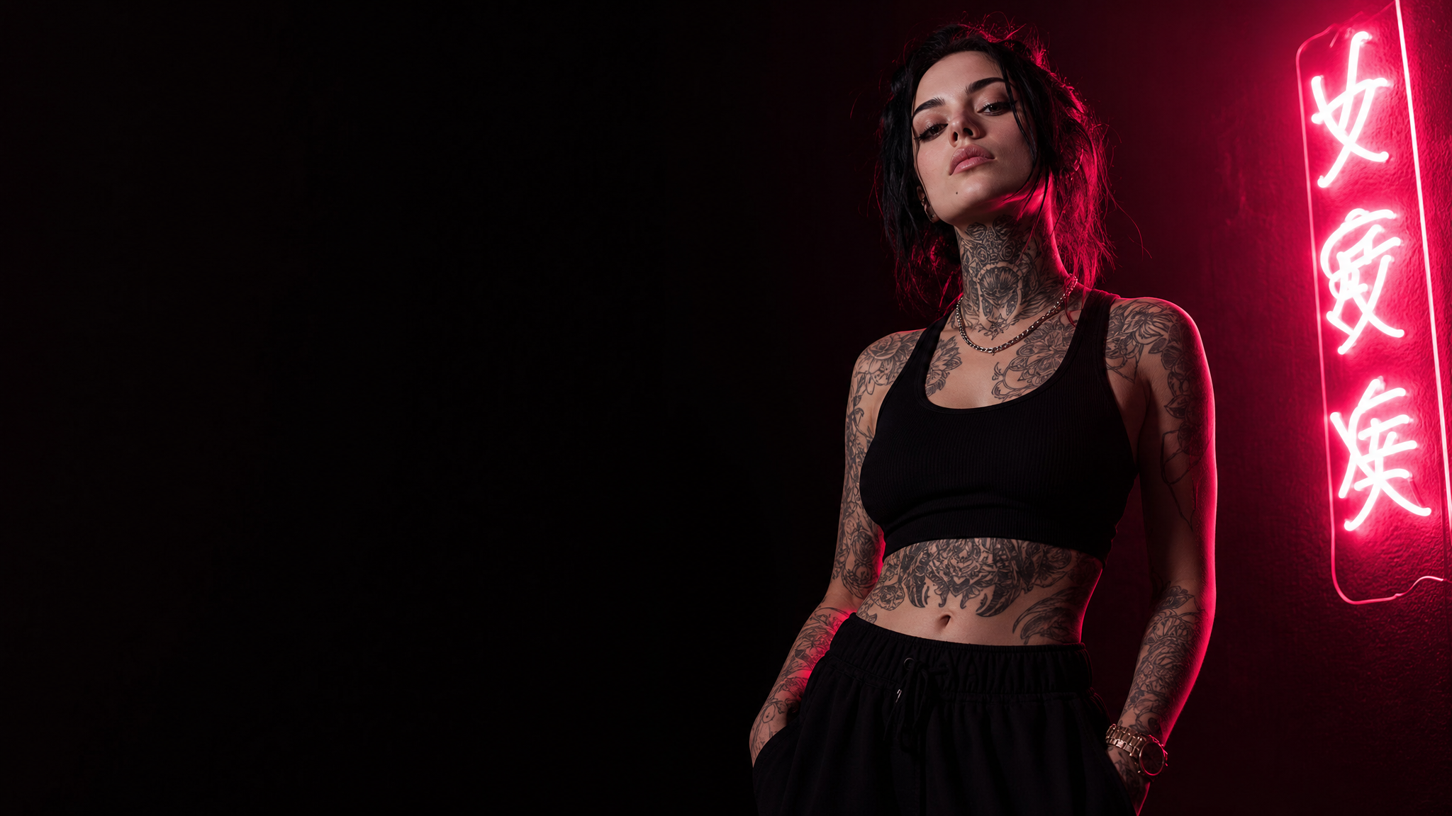 Confident tattooed woman in Pretty Pricks streetwear under hot-pink neon light