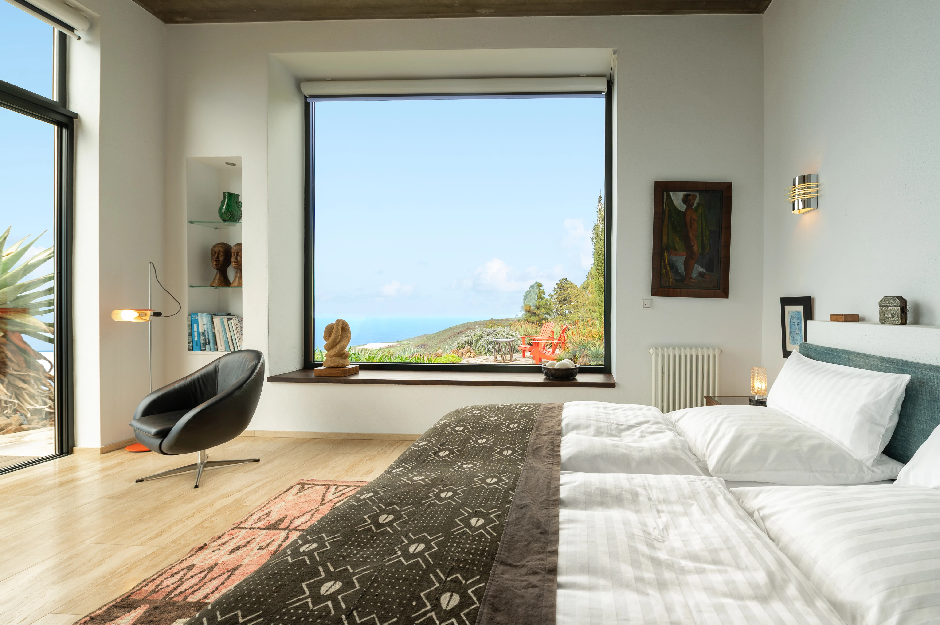 Spacious bedroom with sea-view window and designer furniture