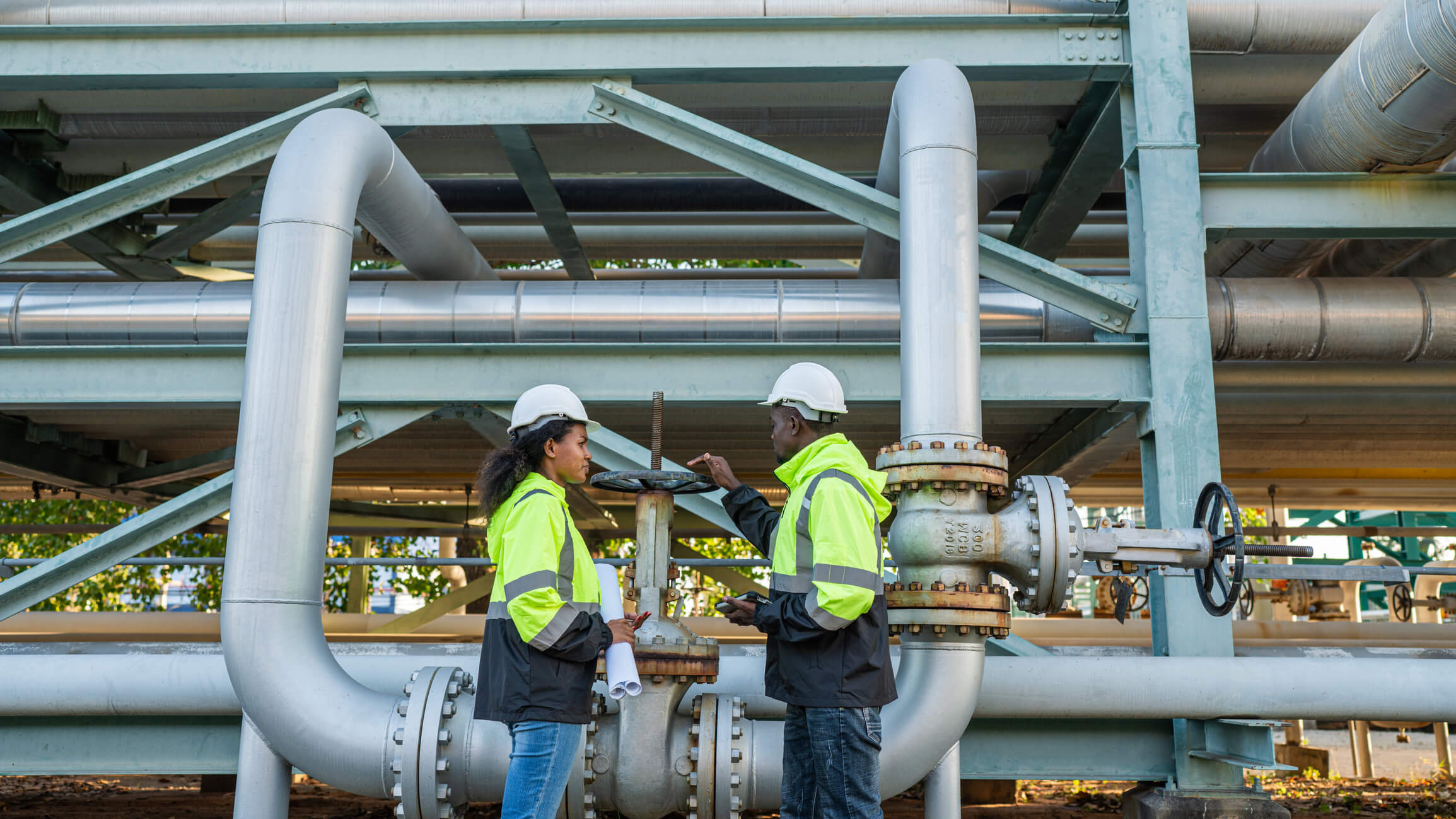 Professional engineering team collaborating at an industrial oil and gas site