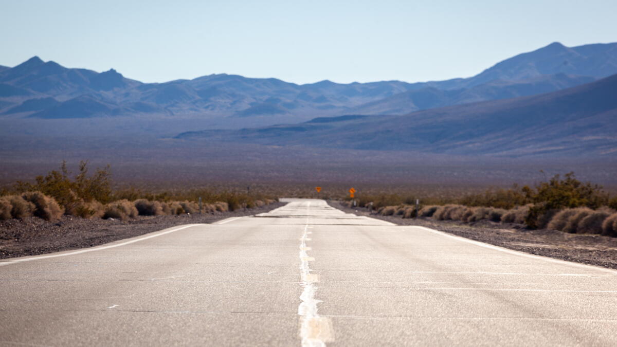Desert highway stretching through the Antelope Valley with mountains in the distance