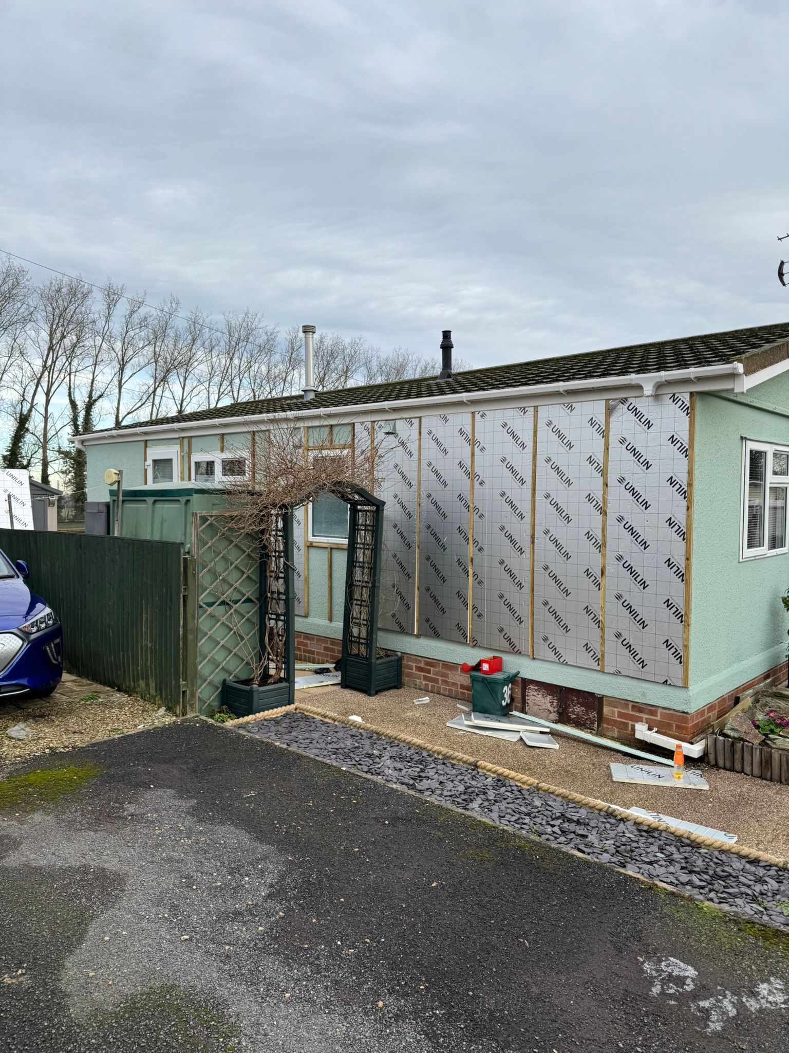 Full side of park home with Unilin insulation boards and ladder during installation