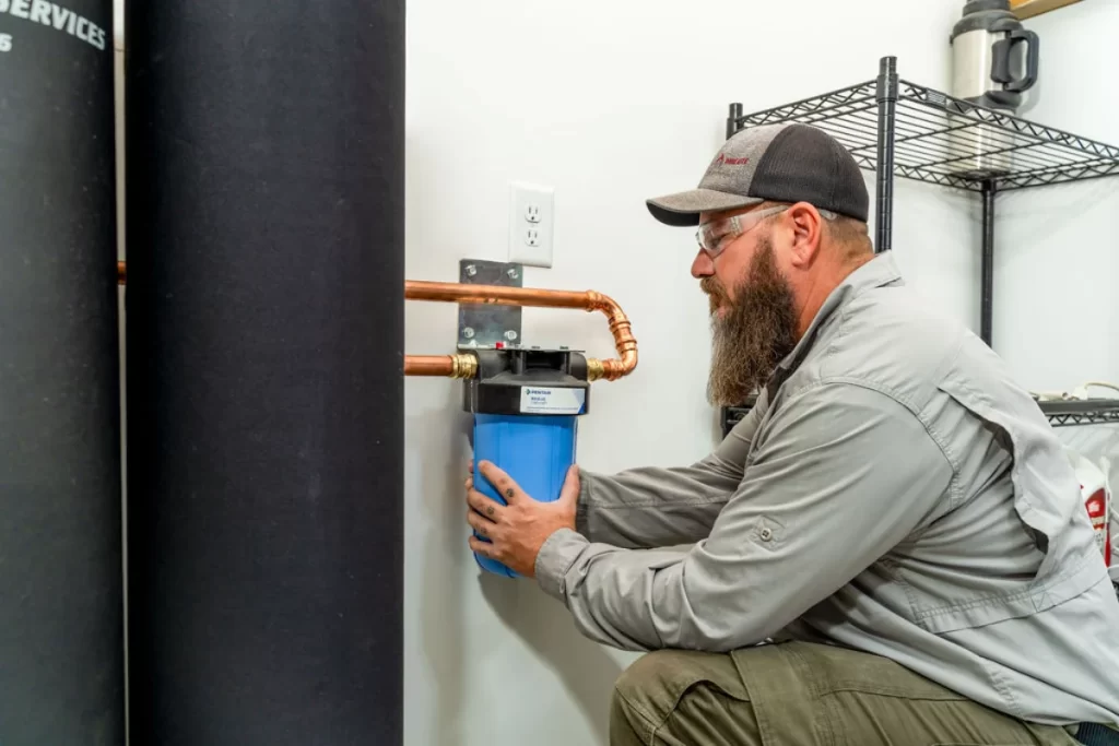 Professional plumber installing a water softener system