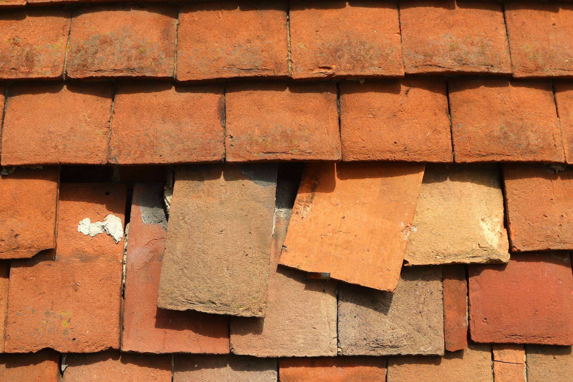 Broken clay roof tiles after storm damage