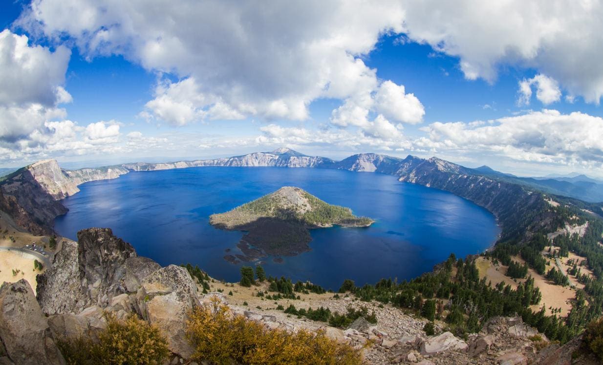 A deep blue circular crater lake inside a volcano caldera