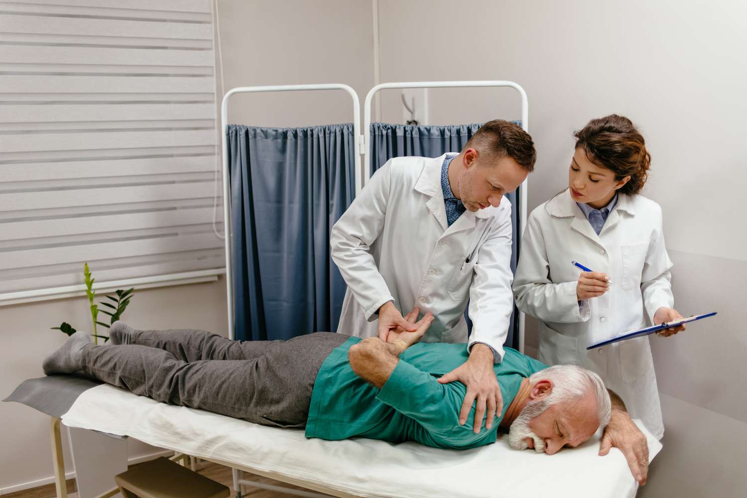 A physical therapist performing a shoulder range-of-motion and impingement test on a patient lying supine