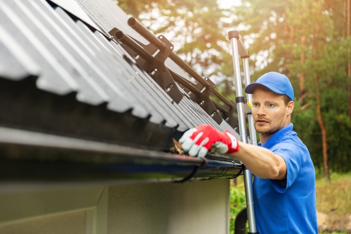 Worker cleaning gutters