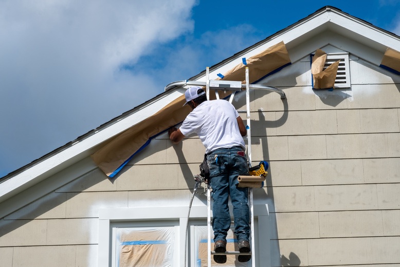 Painter working on house exterior