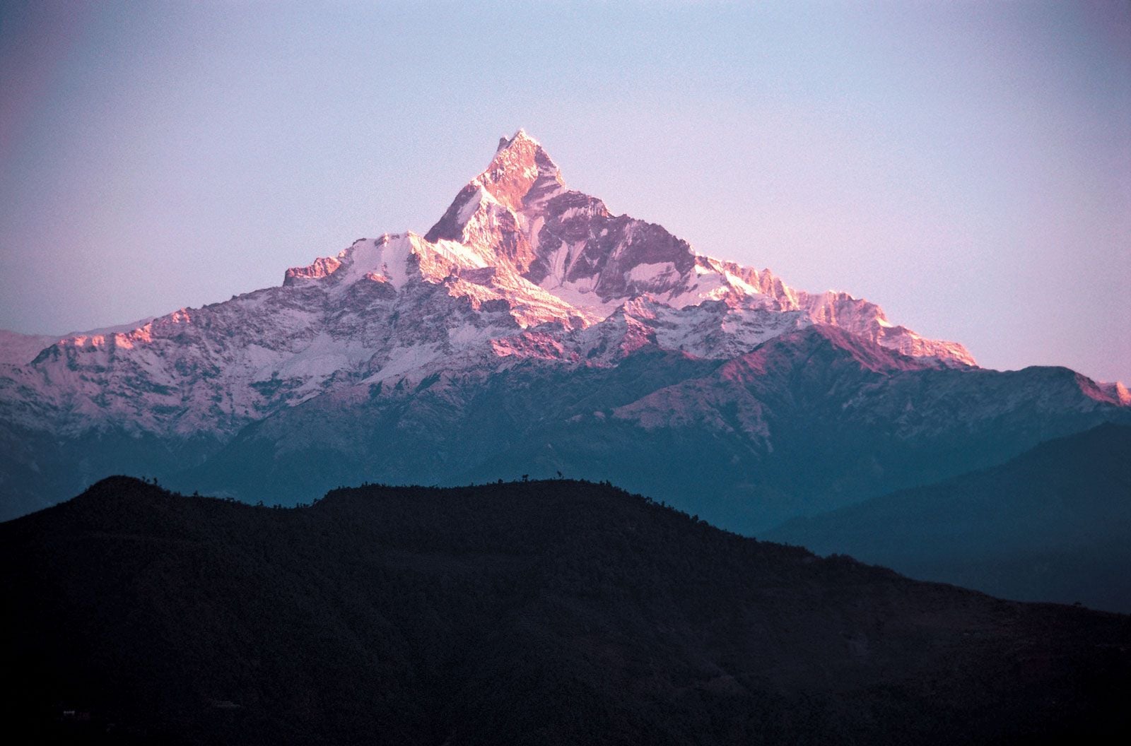 Snow-capped folded mountain range with layered ridges