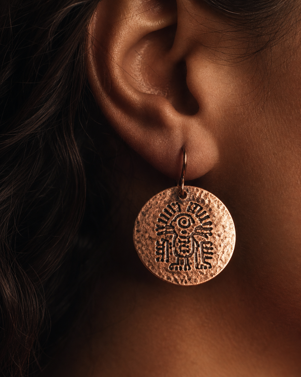 Close-up of the Oaxaca Coin earring by a model's ear