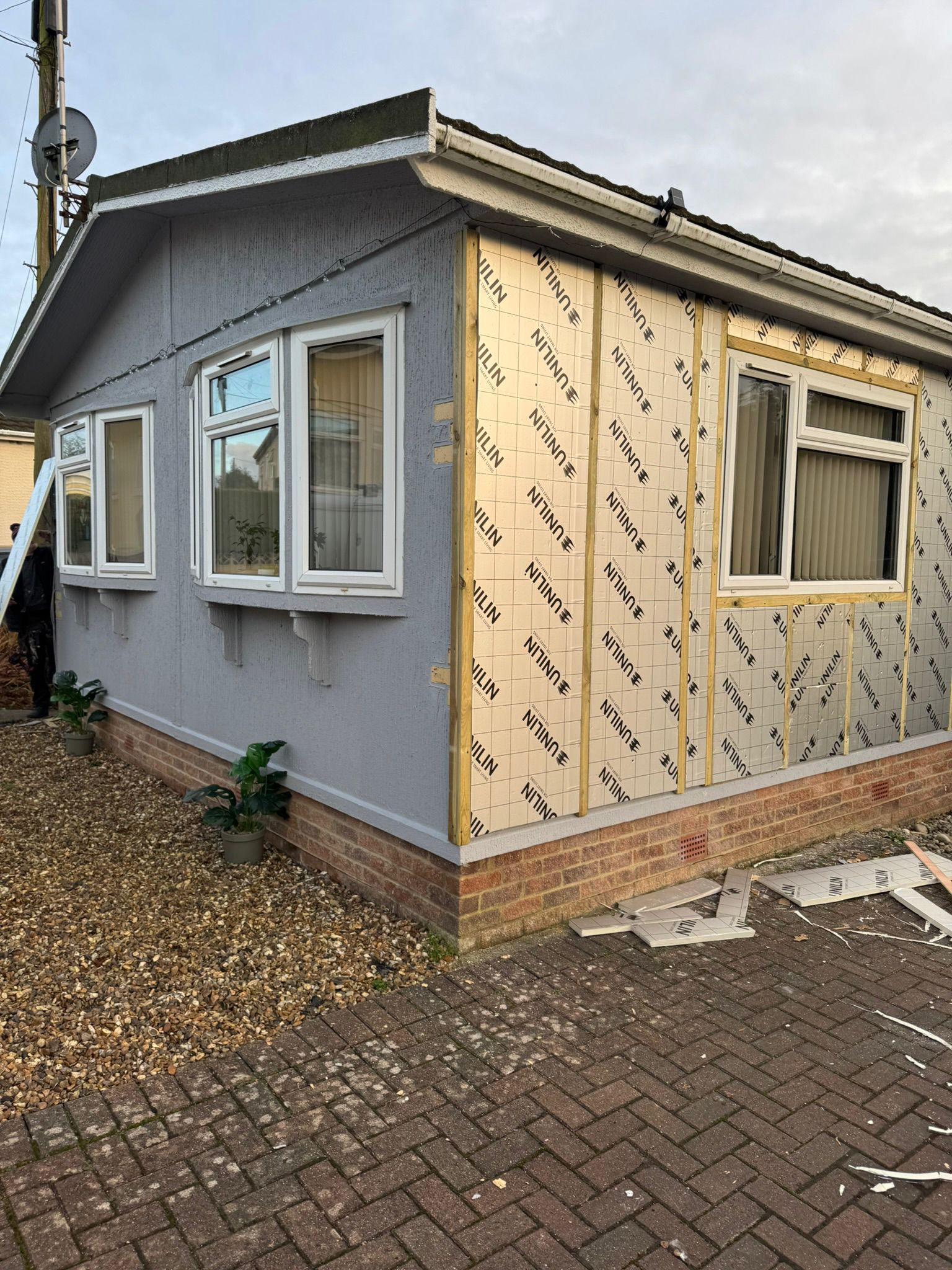 Unilin insulation boards and timber battens being fitted to park home exterior