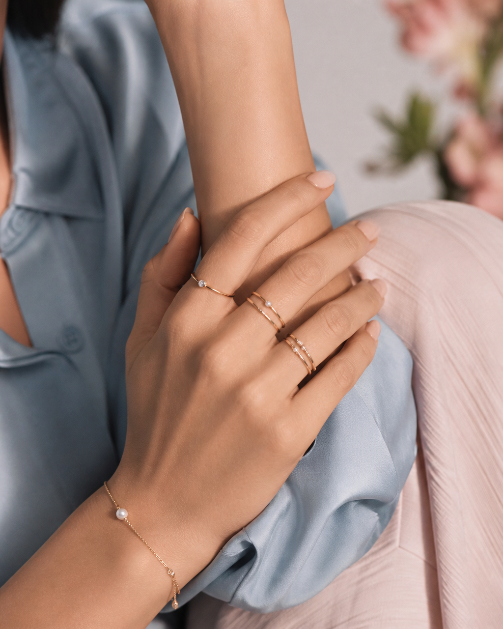 Hands adorned with delicate Platero rings and a pearl bracelet