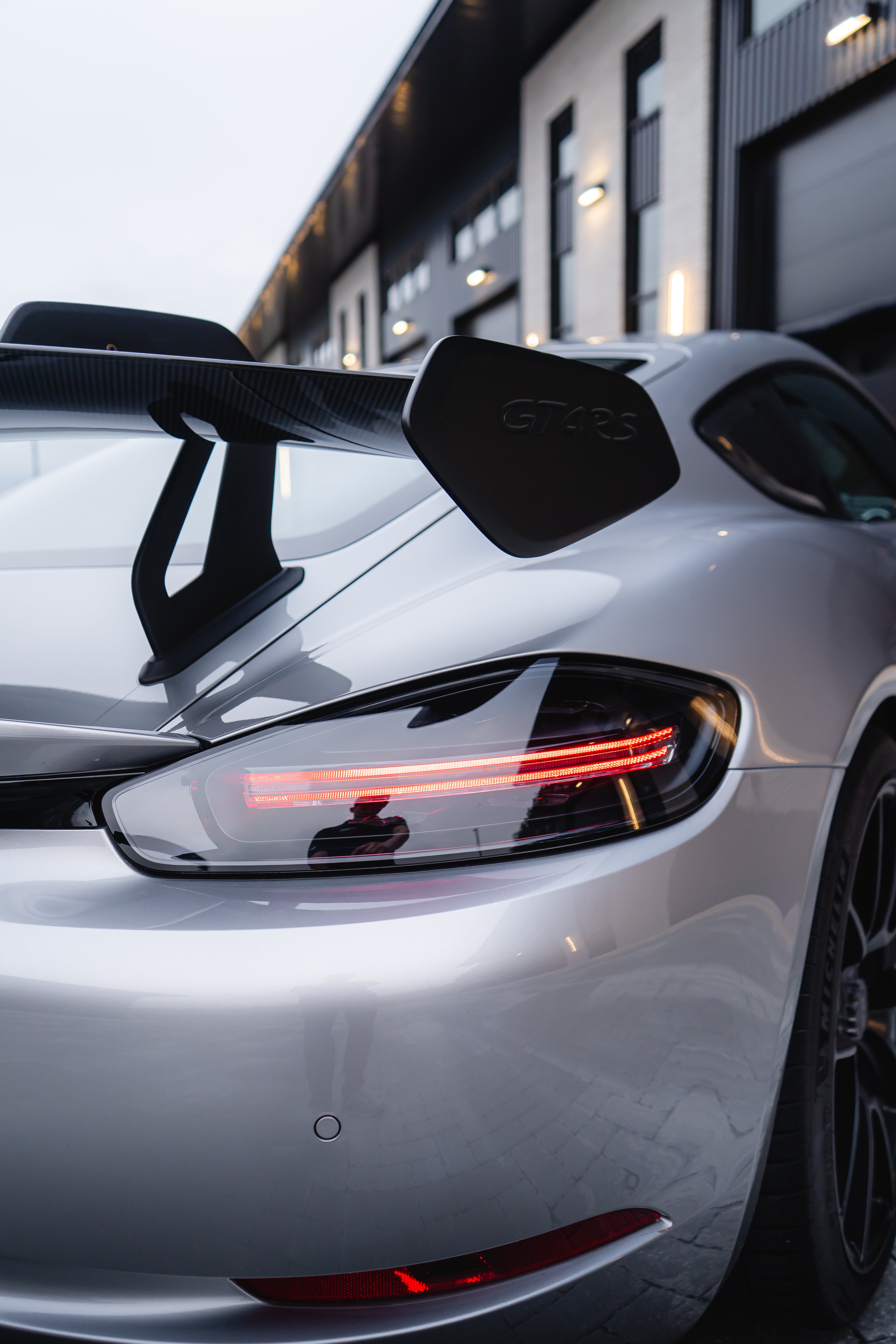 2023 Porsche GT4 RS rear view showing dual exhausts, carbon wing, and diffuser