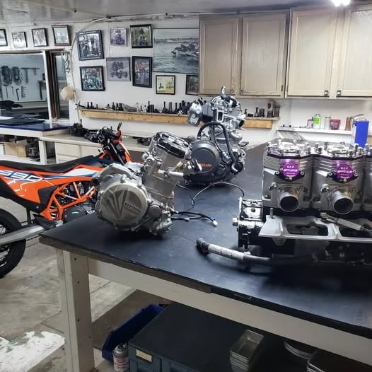 Engines on Joe Benner's bench: a 2023 KTM 690 SMC R, a Yamaha YZ450 and a PSI 1800 triple