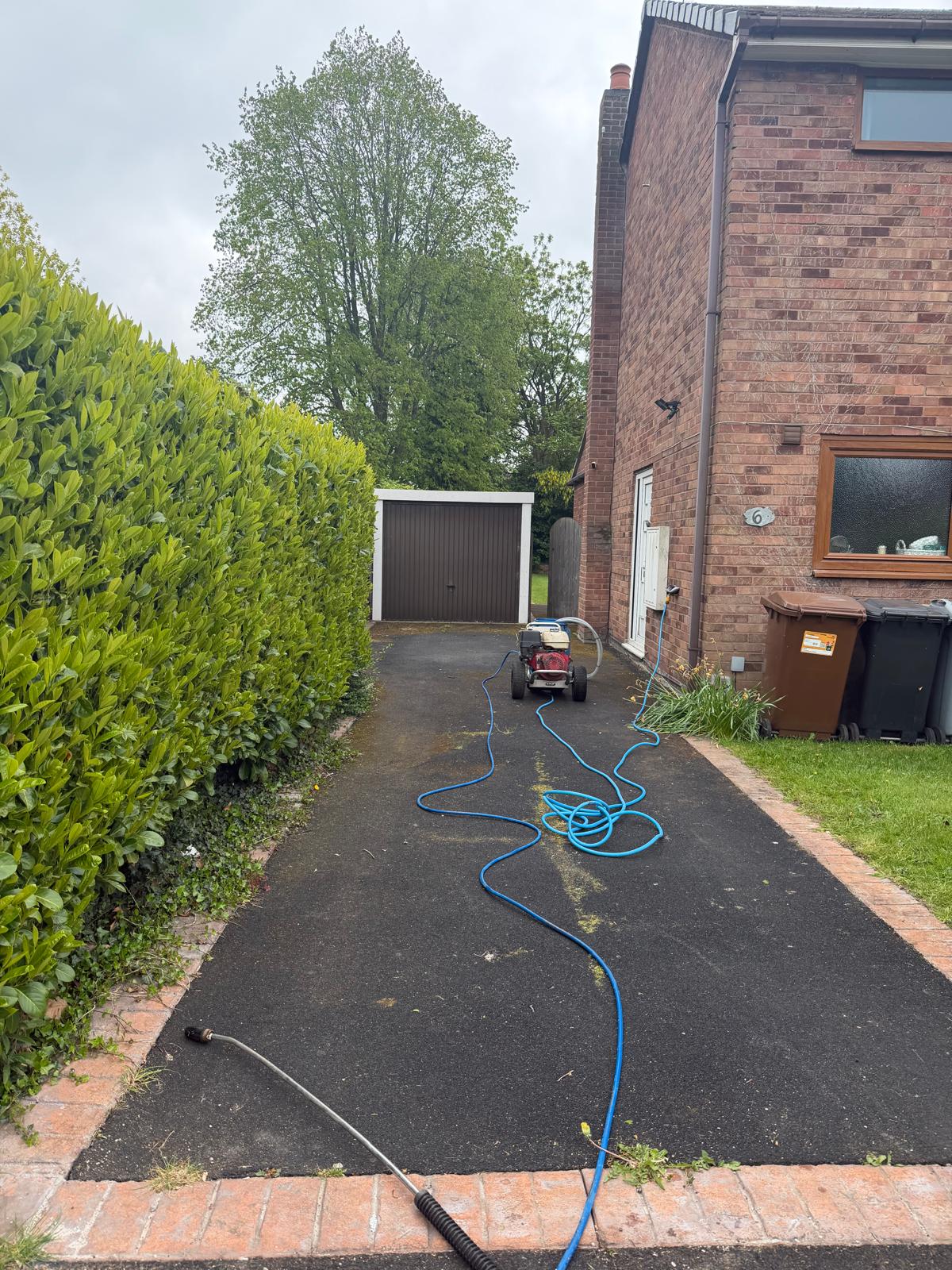 Tarmac driveway after power washing - restored to original dark finish