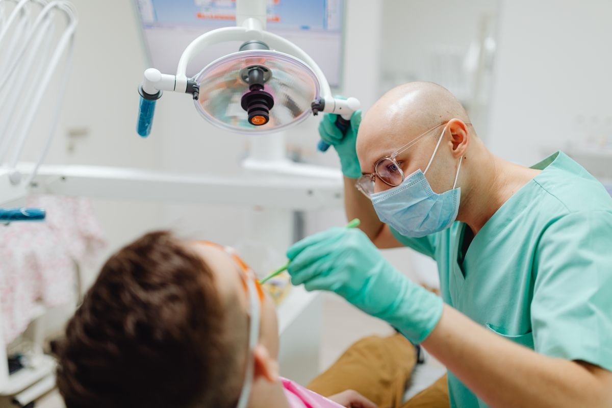 Dental professional providing emergency help for wisdom tooth pain assessment