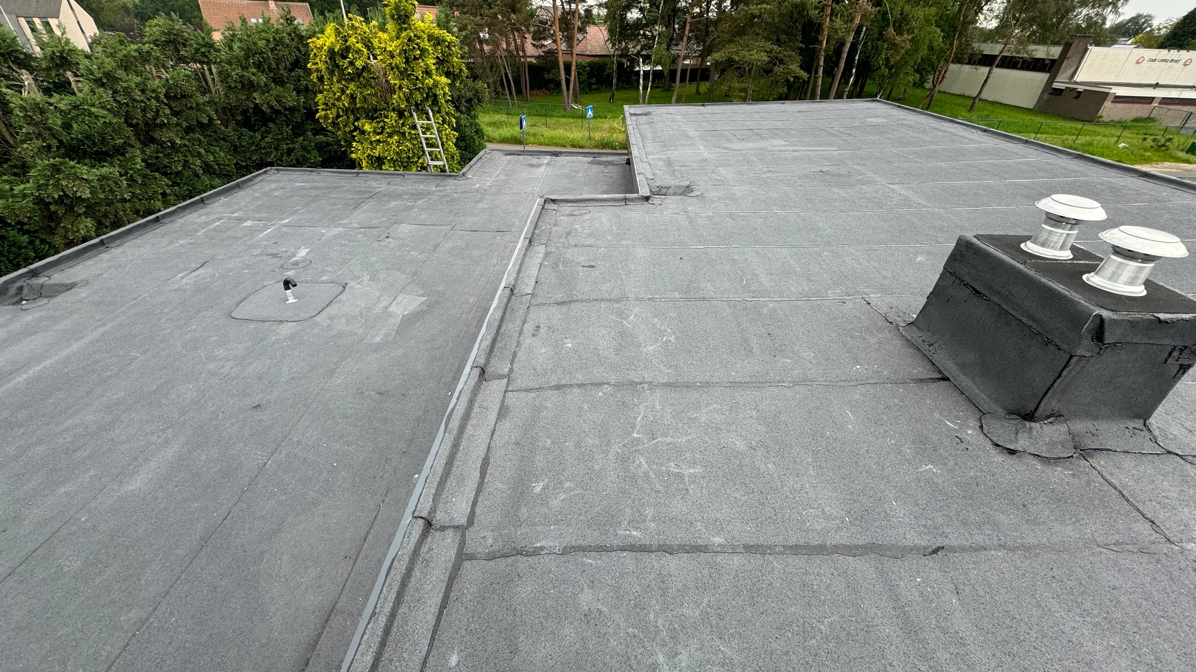 L-vormig plat dak met dakdoorvoeringen
