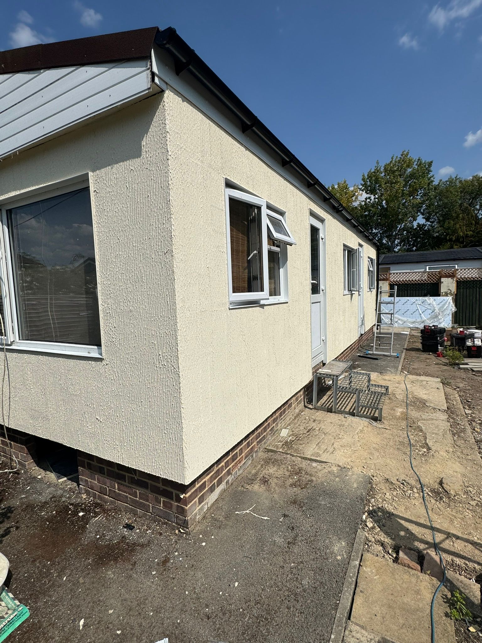 Park home with freshly applied external render on a sunny day