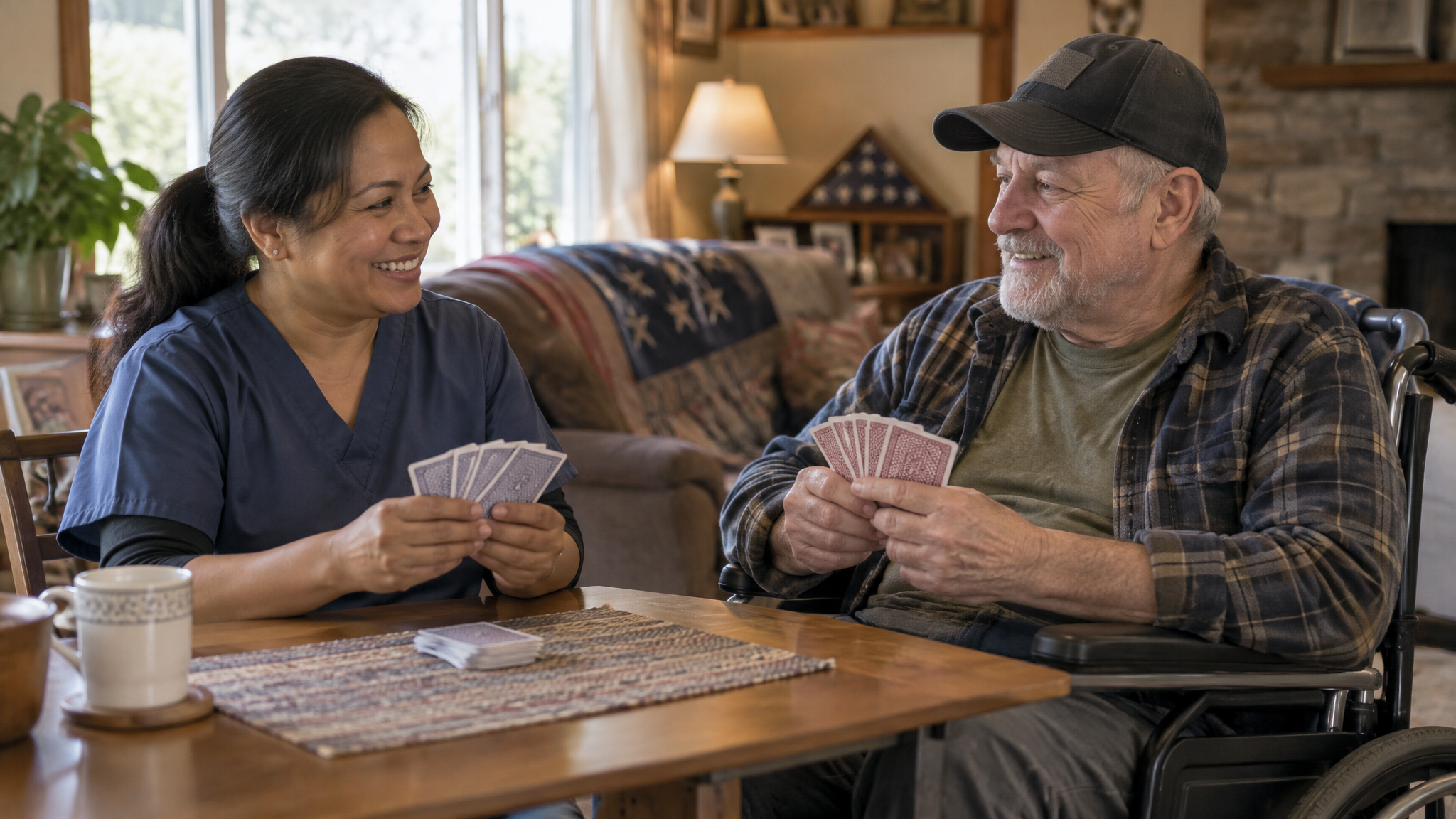 A home health aide playing cards with a veteran in a wheelchair in his living room
