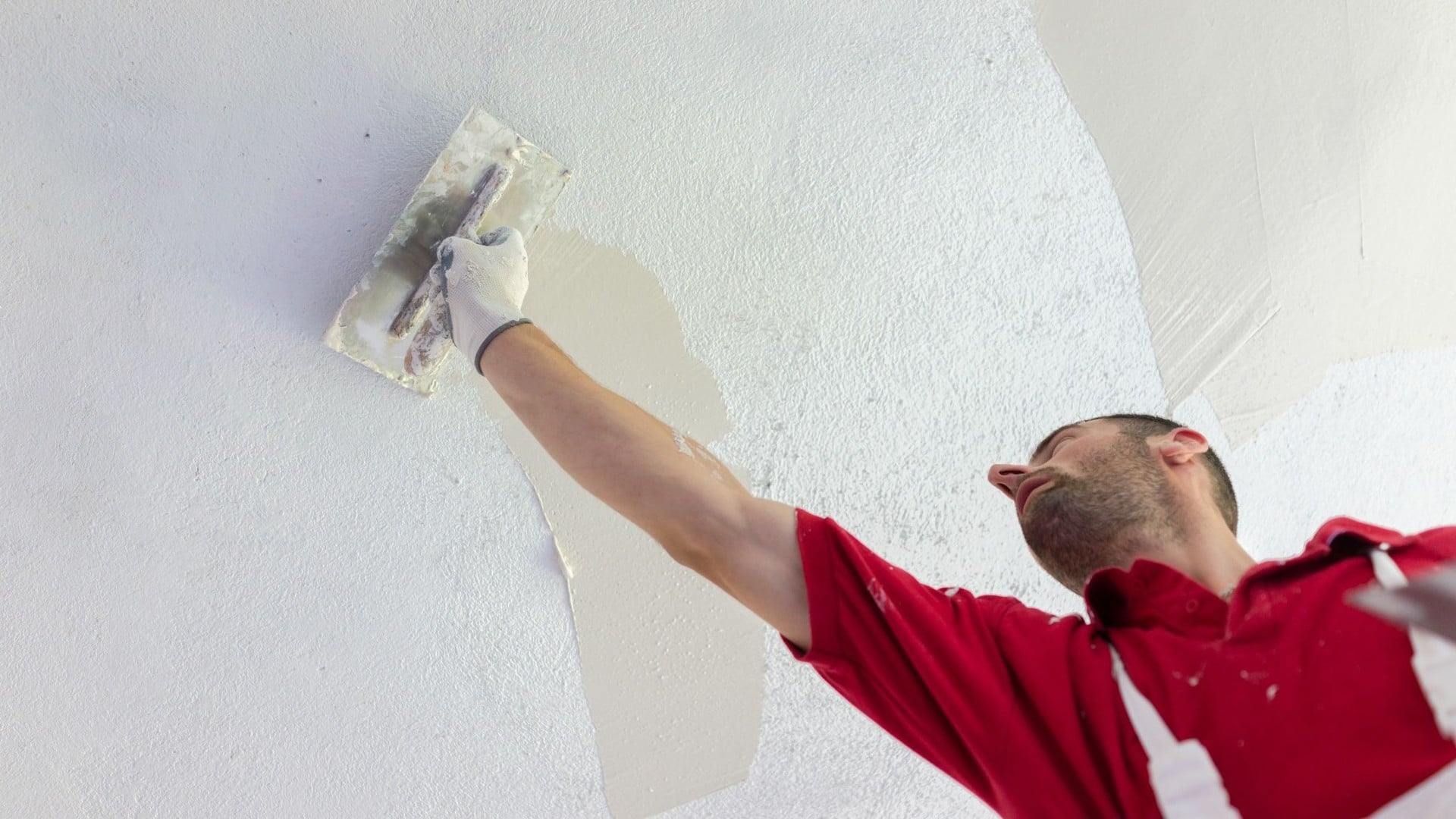 Professional plasterer applying plaster to an interior wall