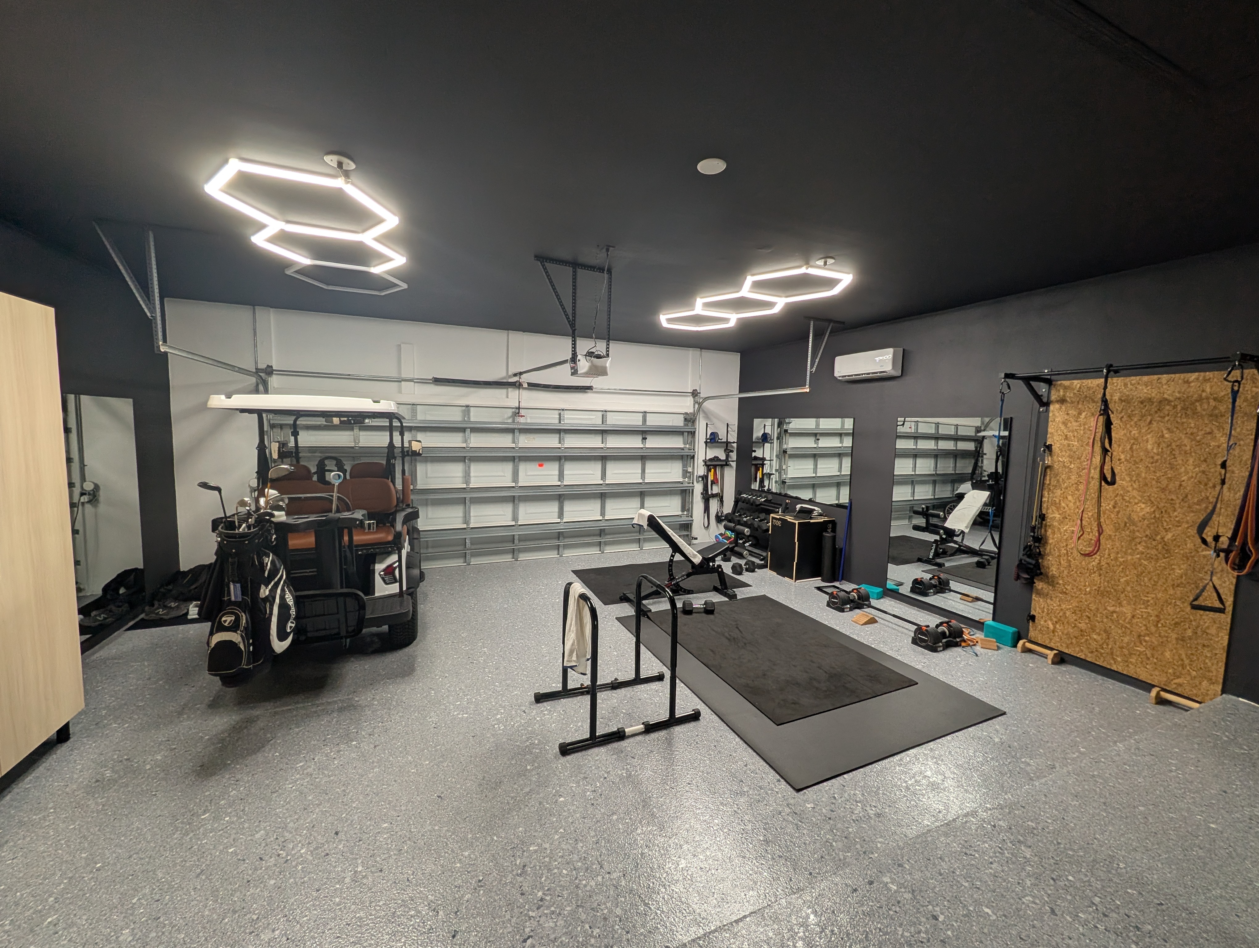 AC epoxy garage gym with hexagon LED lights and workout equipment