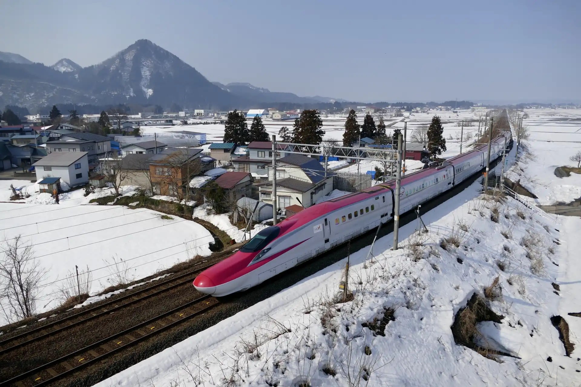 Shinkansen bullet train in a snowy Japanese landscape