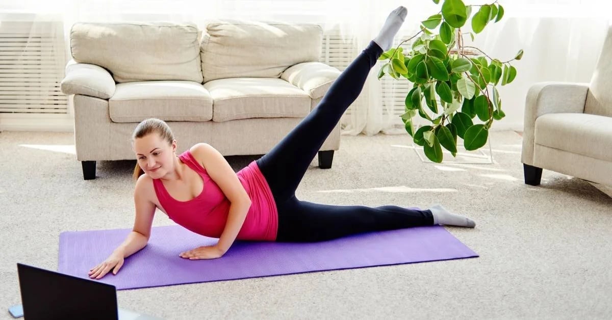 Mulher fazendo pilates em casa com acompanhamento online