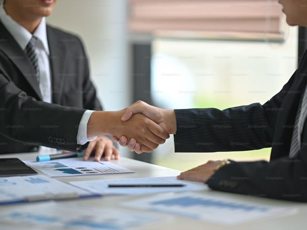 Business professionals in a warm handshake symbolizing trust and partnership