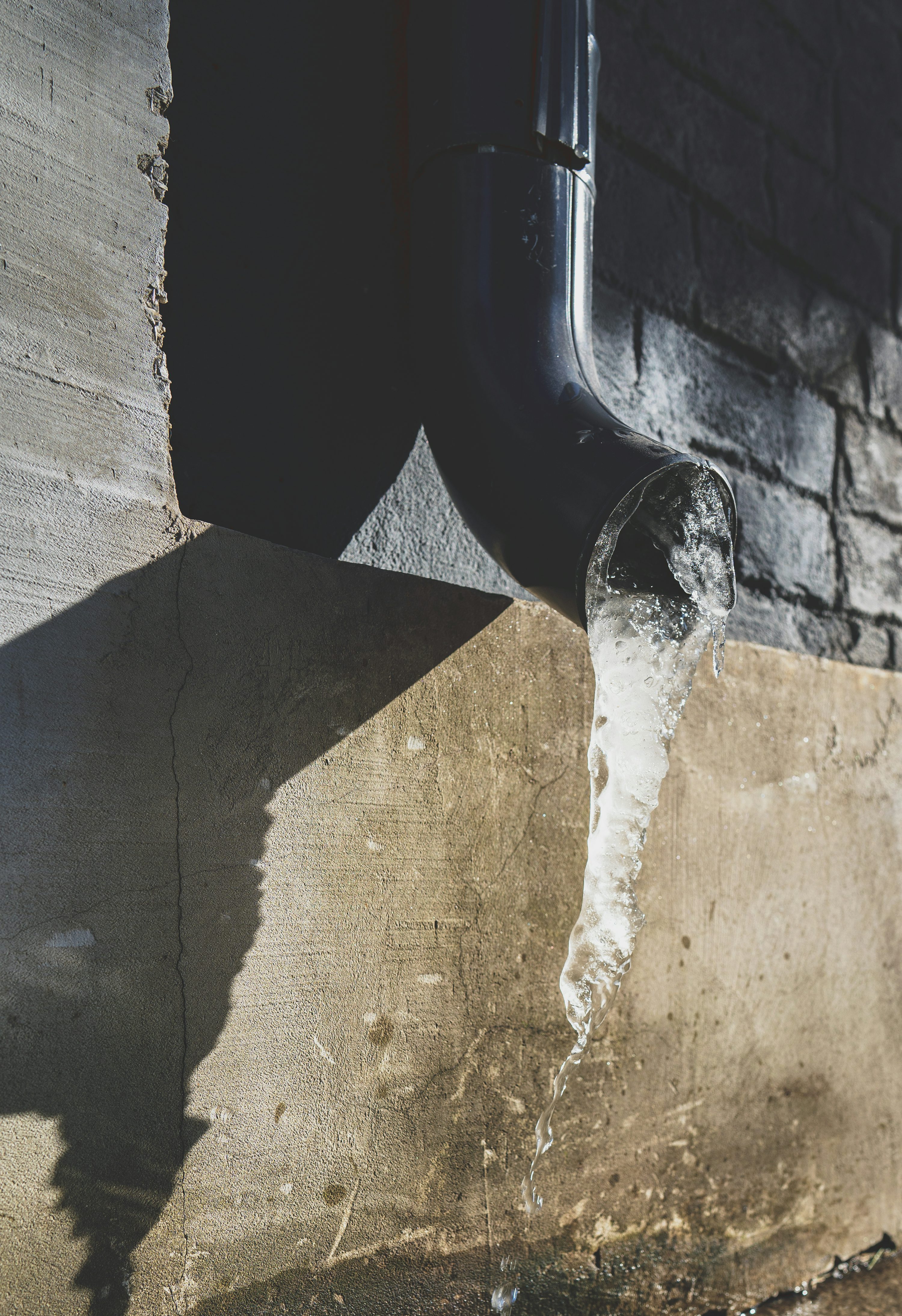 Downpipe fixed to an exterior wall