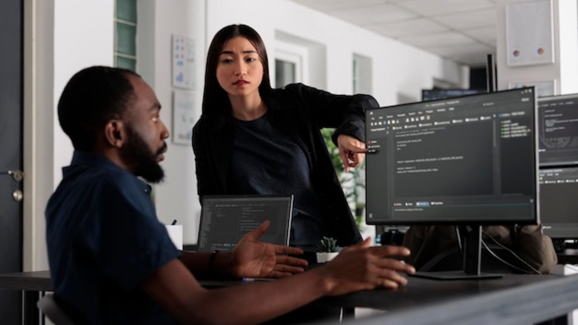 Developers working on AI code on computers in modern office