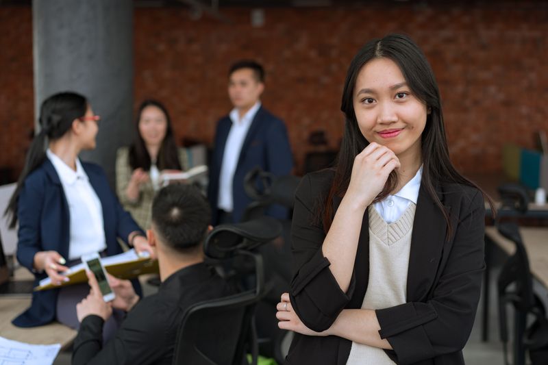 A confident mixed-race professional woman in her late 40s in a striped blazer, conveying a warm and authoritative advocate presence
