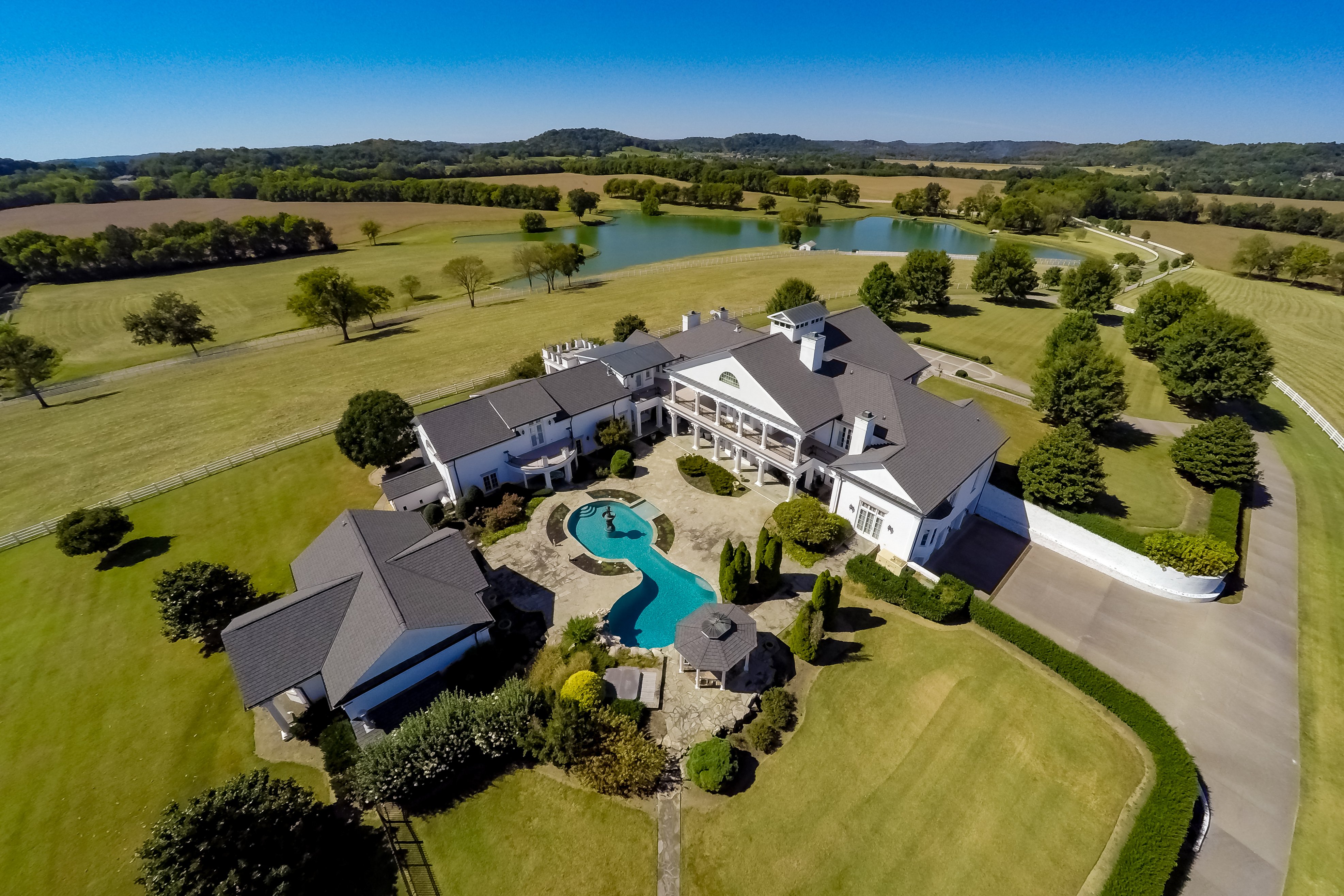 Aerial view of a luxury home property with landscaping