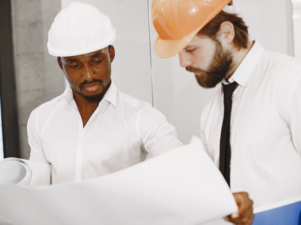 Engineers reviewing construction blueprints on site