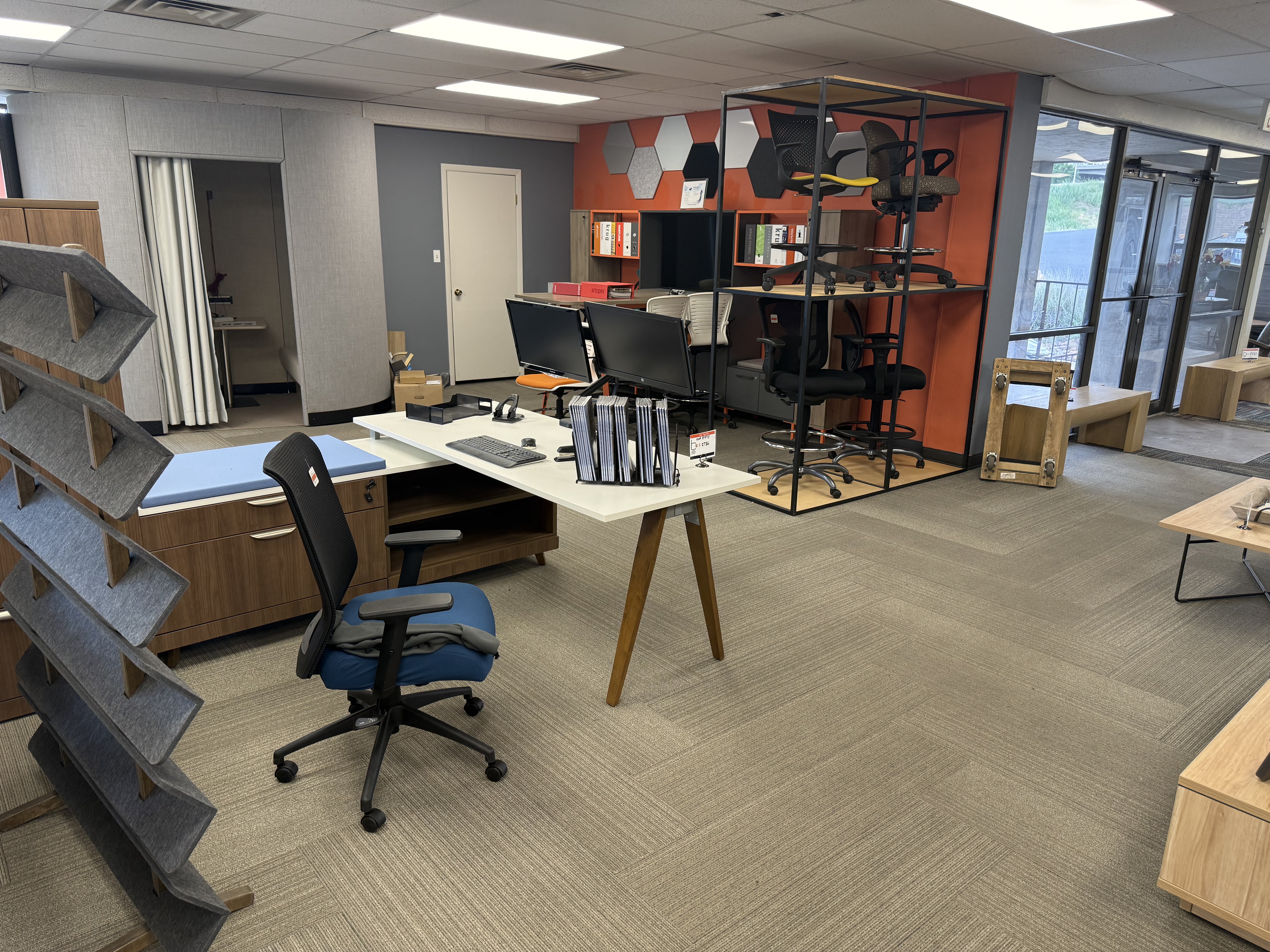 Modern desk setups with ergonomic chair display rack in the BFS showroom
