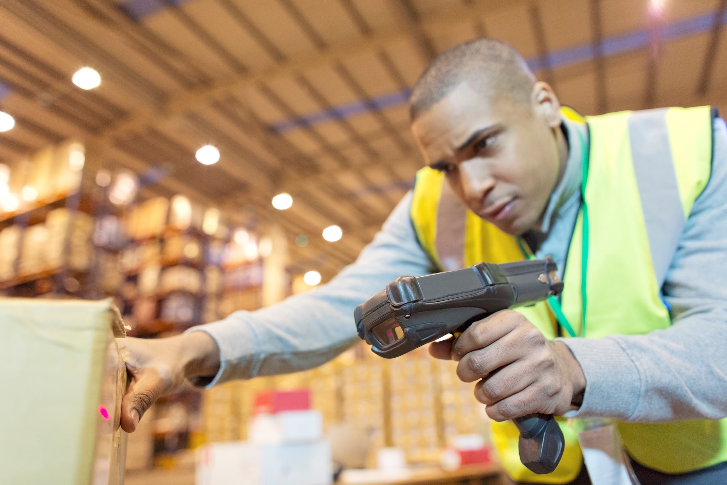 Warehouse worker scanning packages in modern fulfillment center