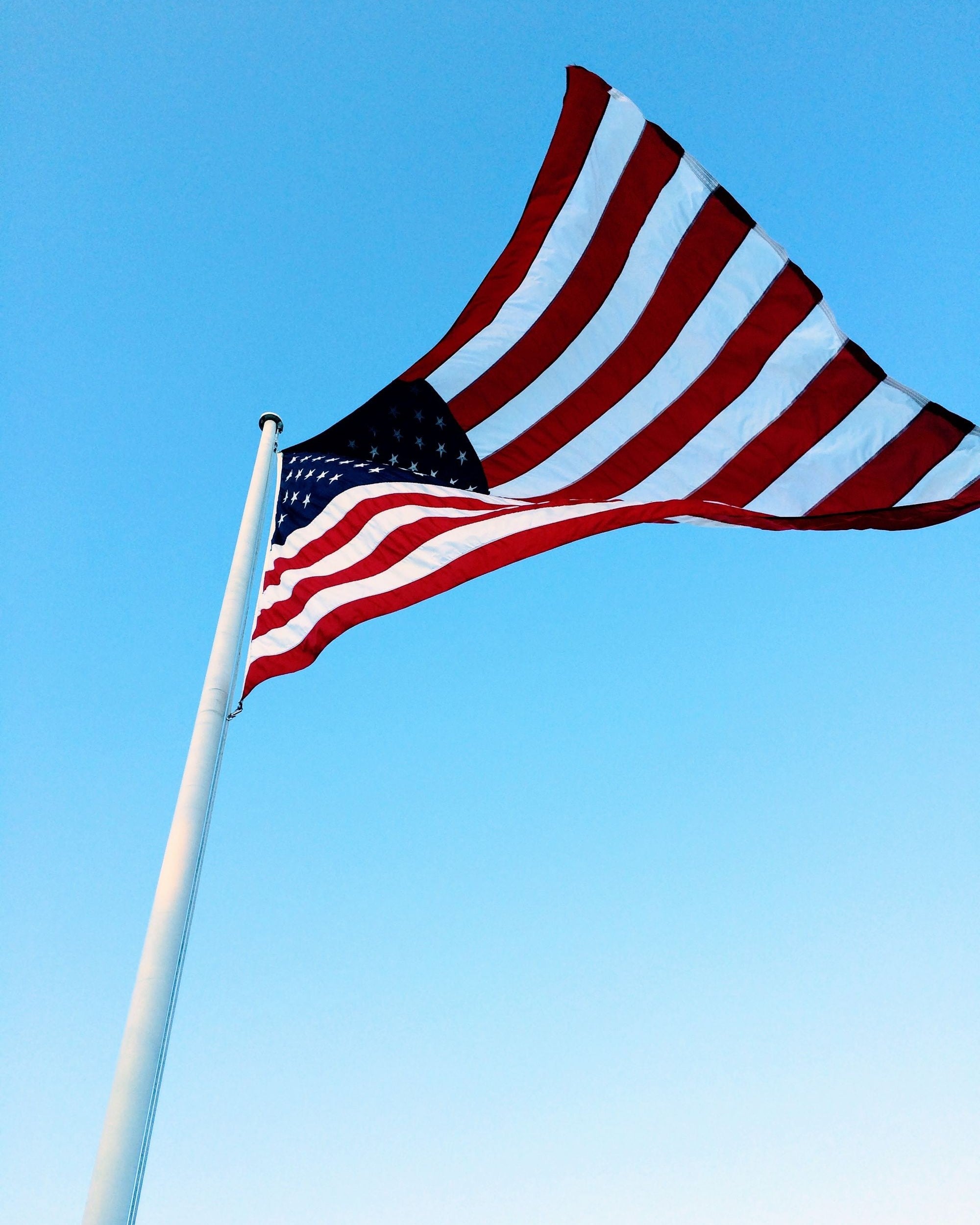 American flag waving against a blue sky