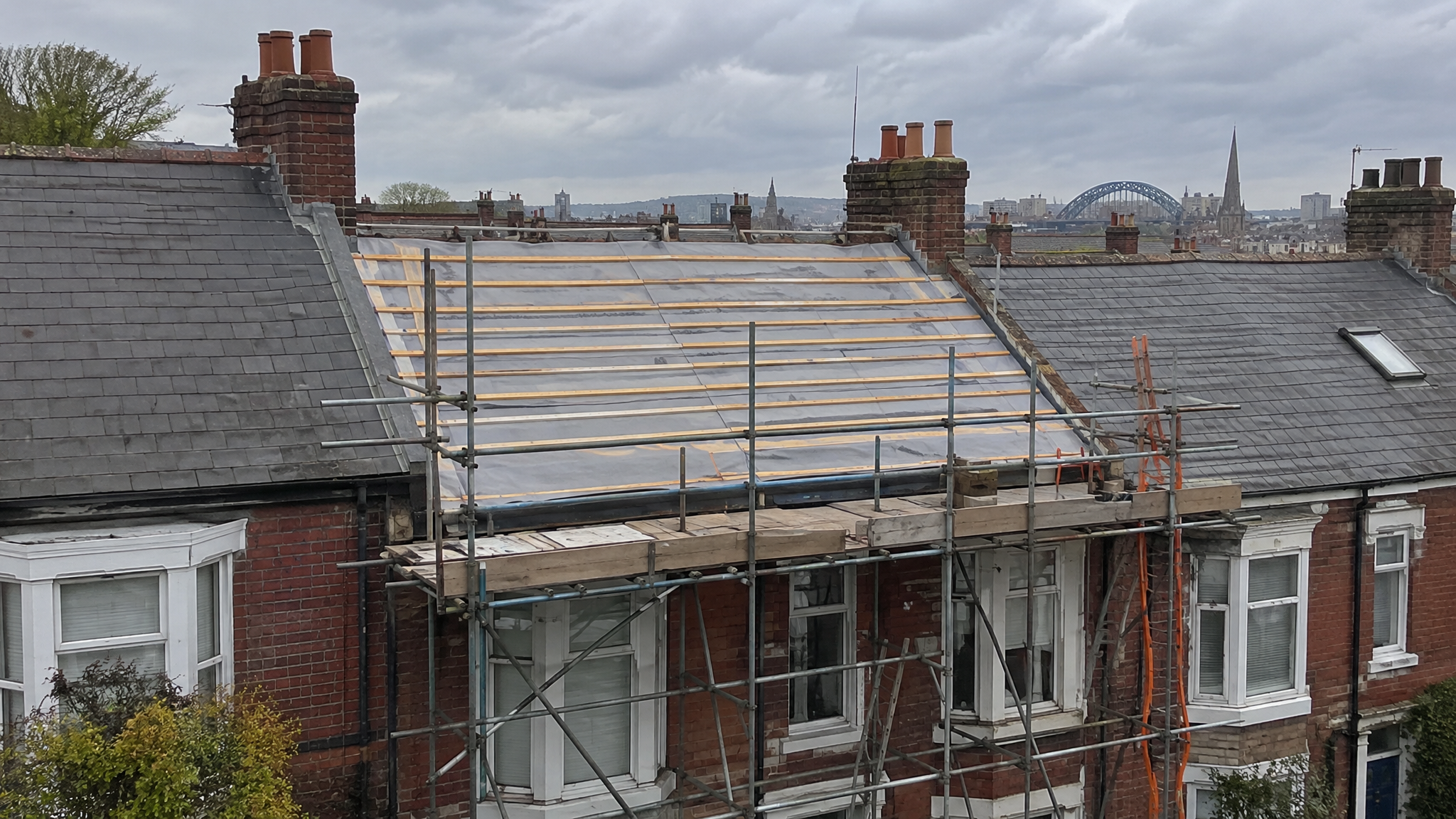 Re-roof in progress on UK terraced house with scaffolding
