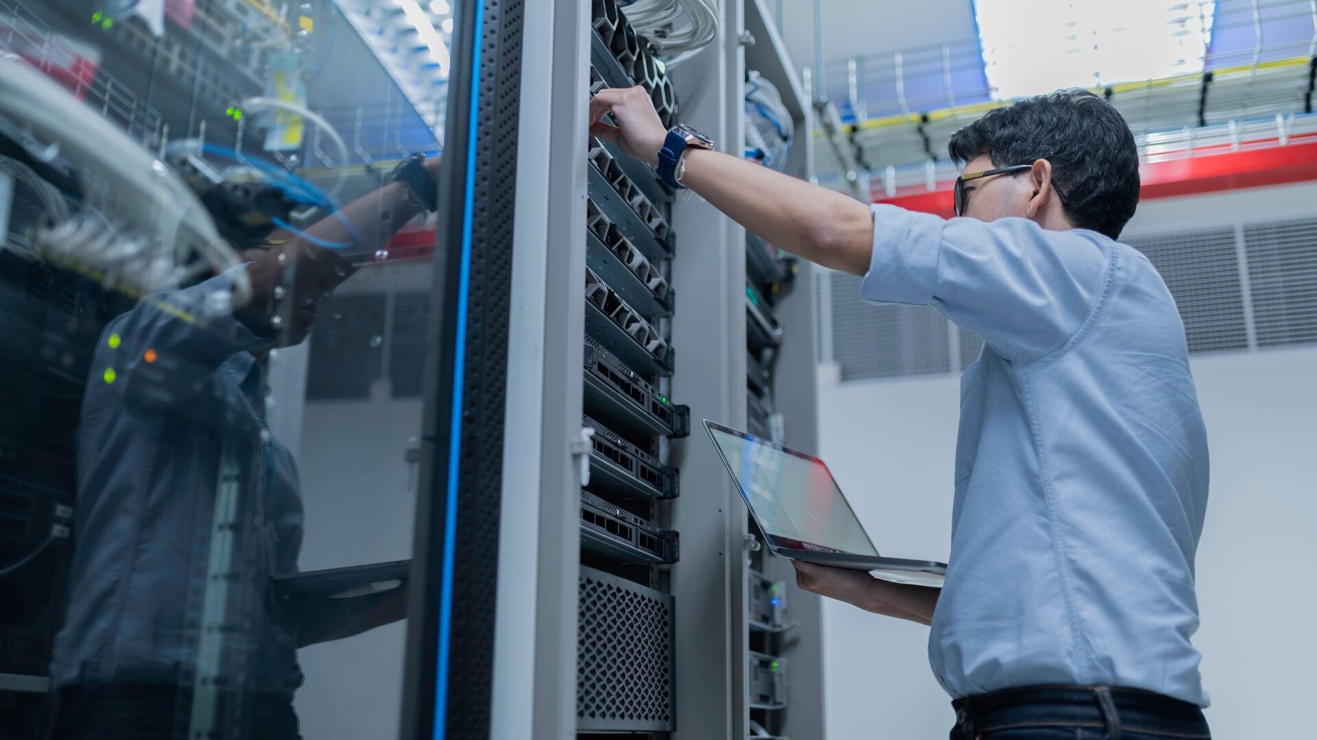 Engineer configuring technology systems in server room