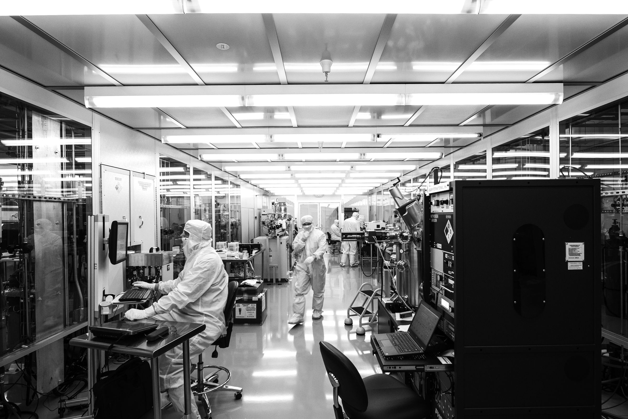 Team of scientists and engineers collaborating on quantum computing hardware in a high-tech laboratory facility