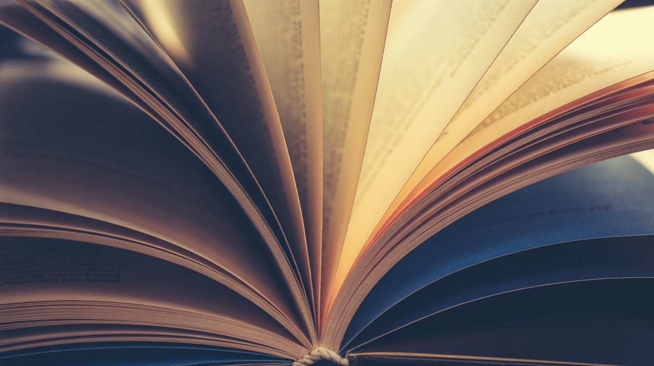 Book pages fanning open with golden light representing publishing services