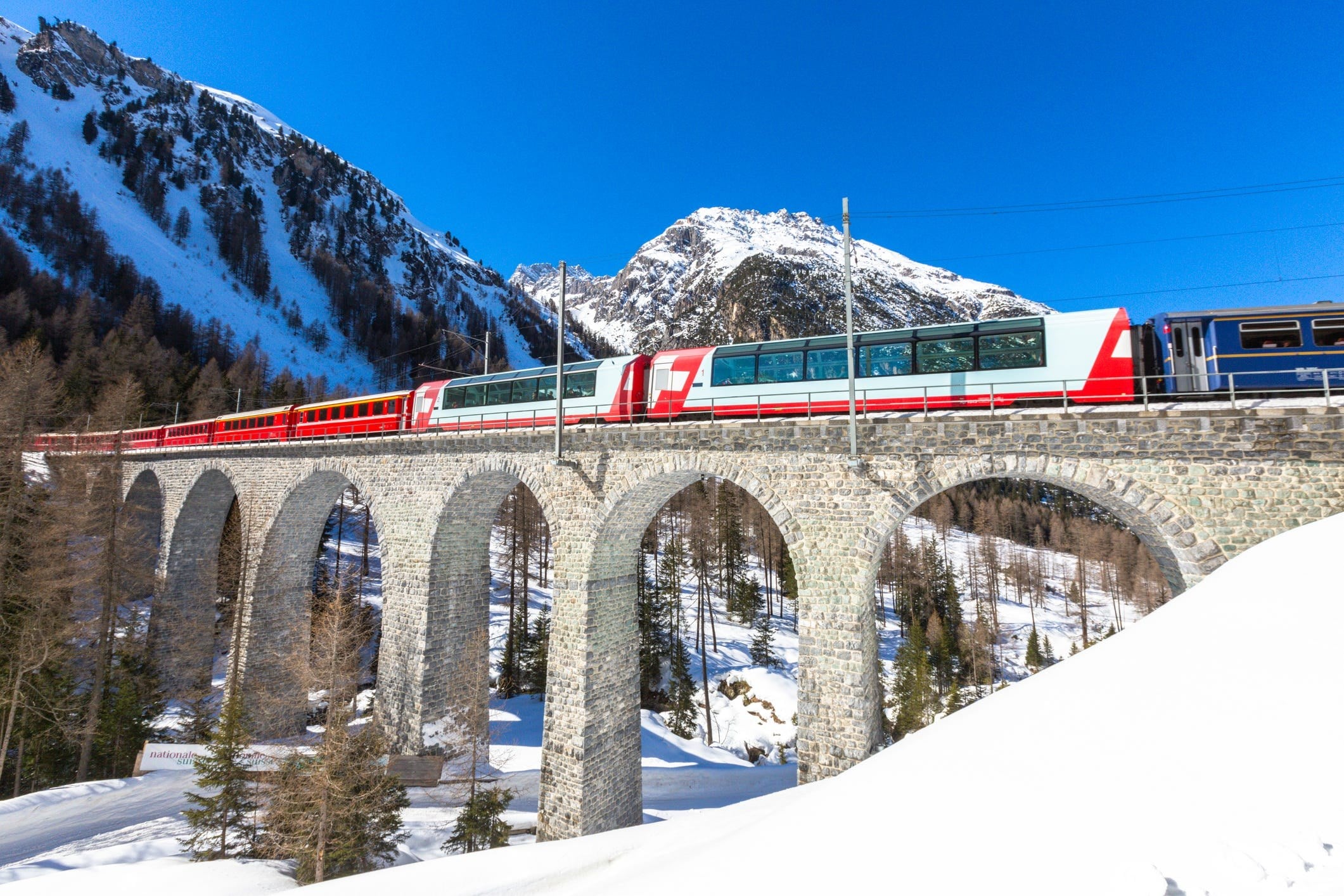 Scenic train crossing a viaduct in the Swiss Alps