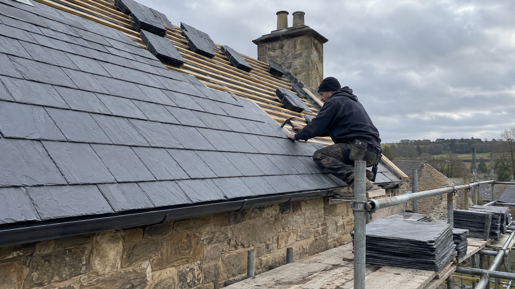 Natural slate roof being laid on stone UK house