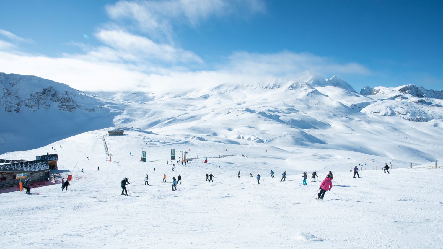 Panoramic view of skiers on Val d'Isère slopes with Alps mountain backdrop